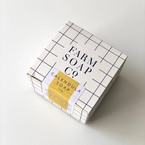 A plain background with 110g box of Calendula hair and body soap by Farm Soap Co