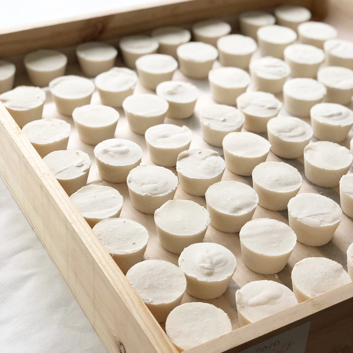 A wooden tray covered in naked Geranium soap bars