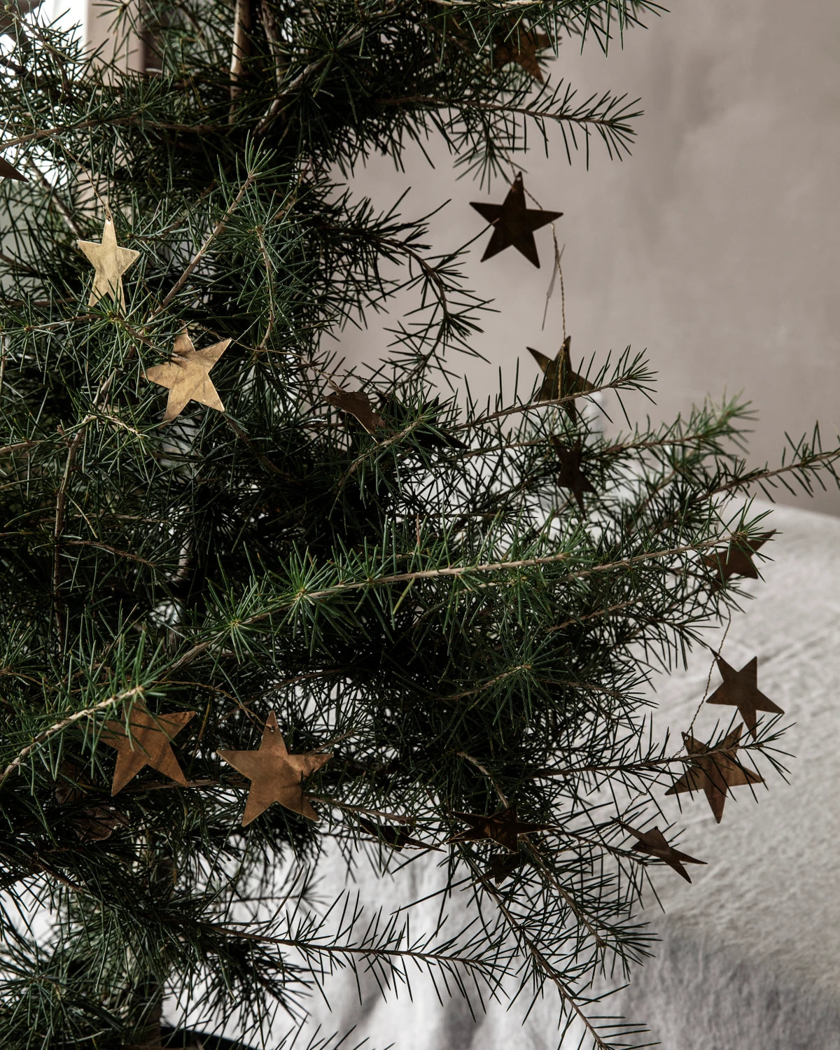 House Doctor antique brass star garland draped on a fir tree