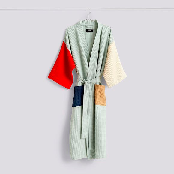 HAY Waffle bathrobe hanging on a hanger, in light glacier green blue with colour block patterns