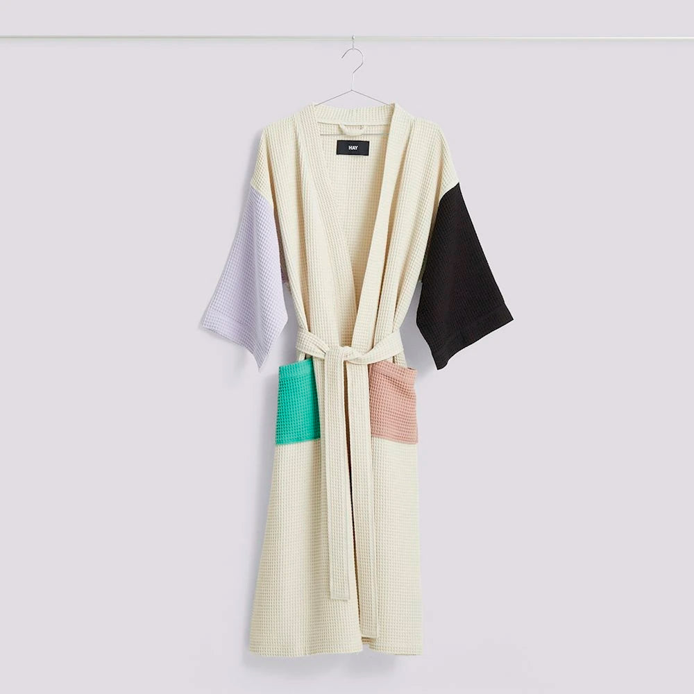 HAY Waffle bathrobe hanging on a hanger, in off white with colour block patterns