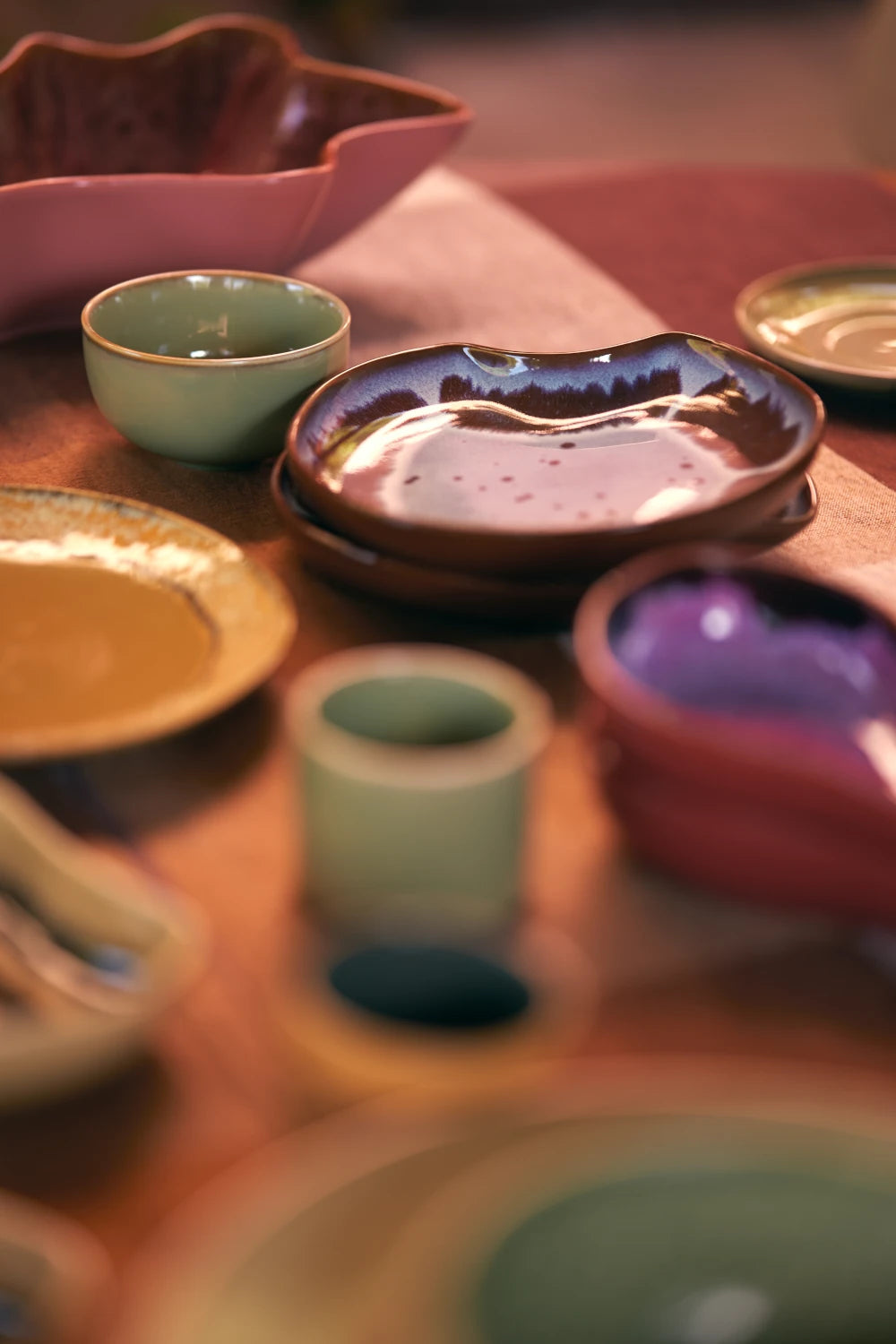 HKLIVING Ceramic Shell Plate in Sienna on a white background on a laid table amongst other ceramics from the collection