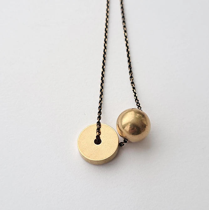 Hiku Necklace featuring a heavy brass ball and thick brass disc on a black brass chain by Brass and Bold