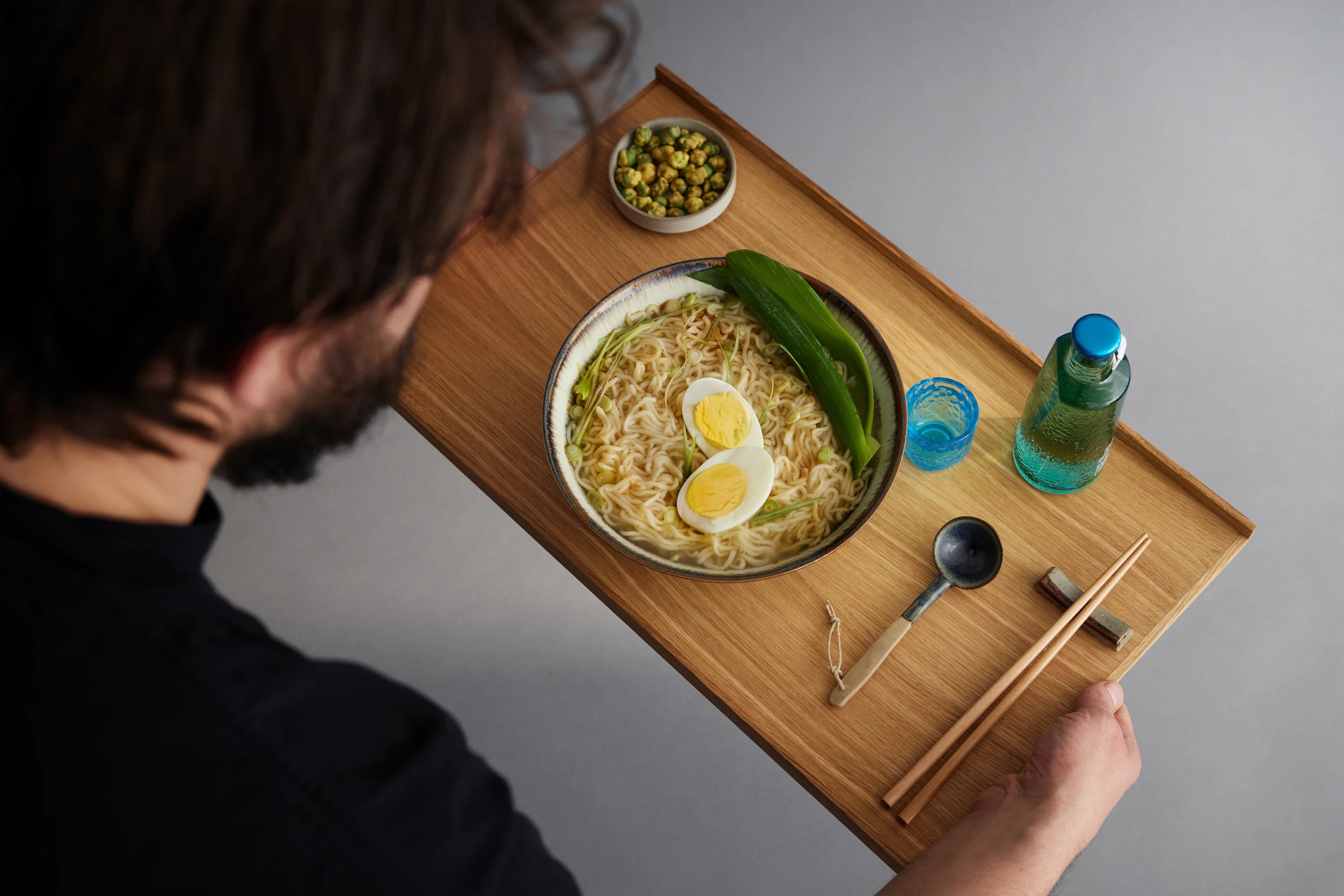 A man carrying Moebe small oak tray with dinner on it | Lifestory