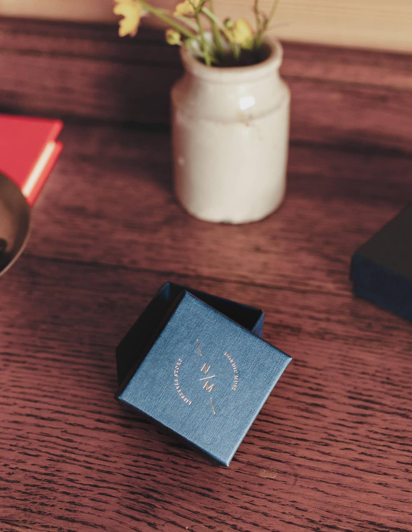 A wooden table with a Nordic Muse branded jewellery box