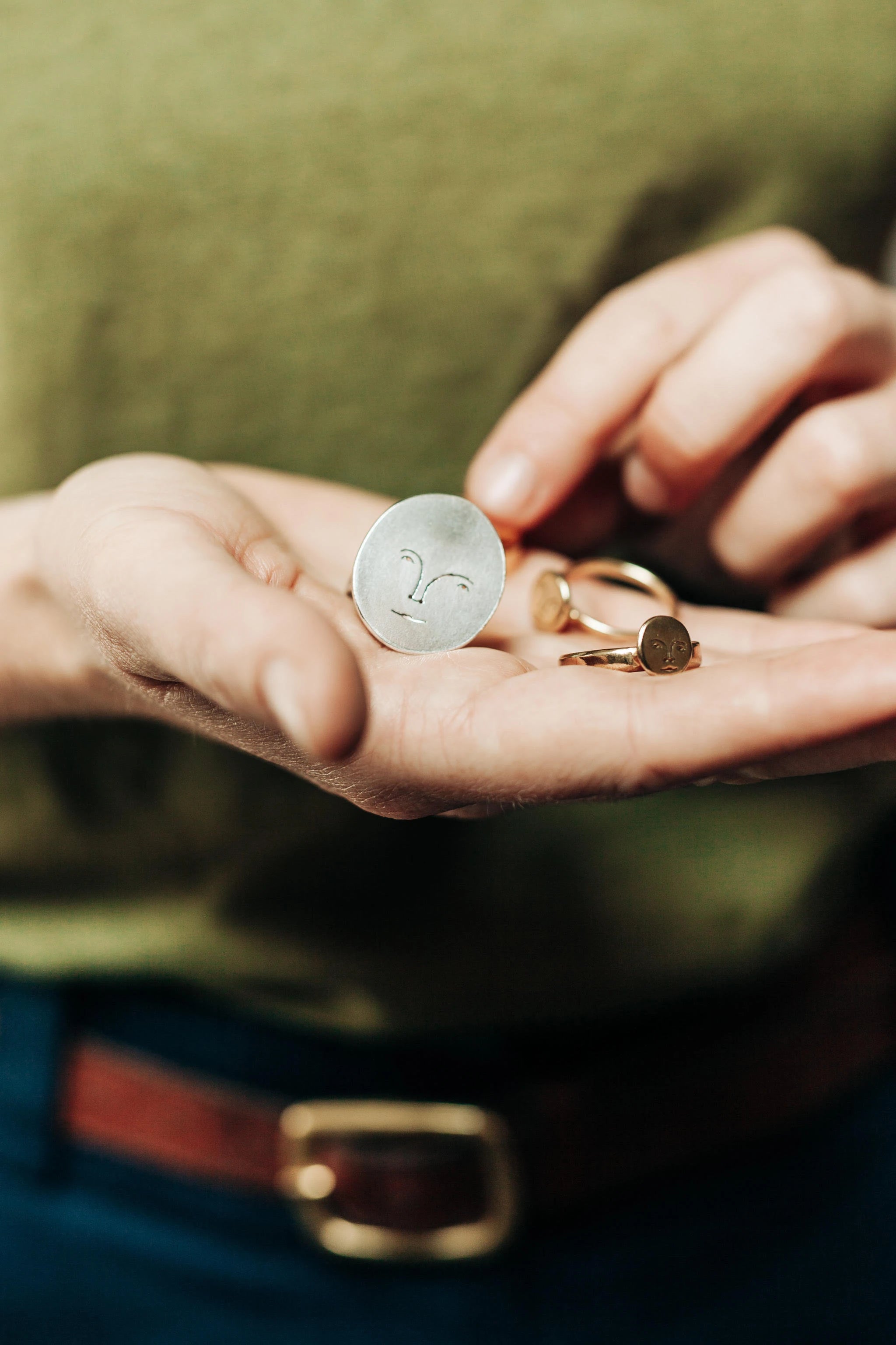 Polly Collins' hands holding some of her moon jewellery