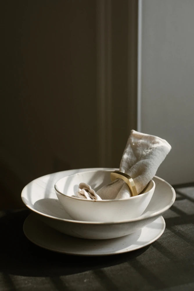 Brushed Brass Napkin Ring with speckled cream plates by The Conran Shop | Lifestory