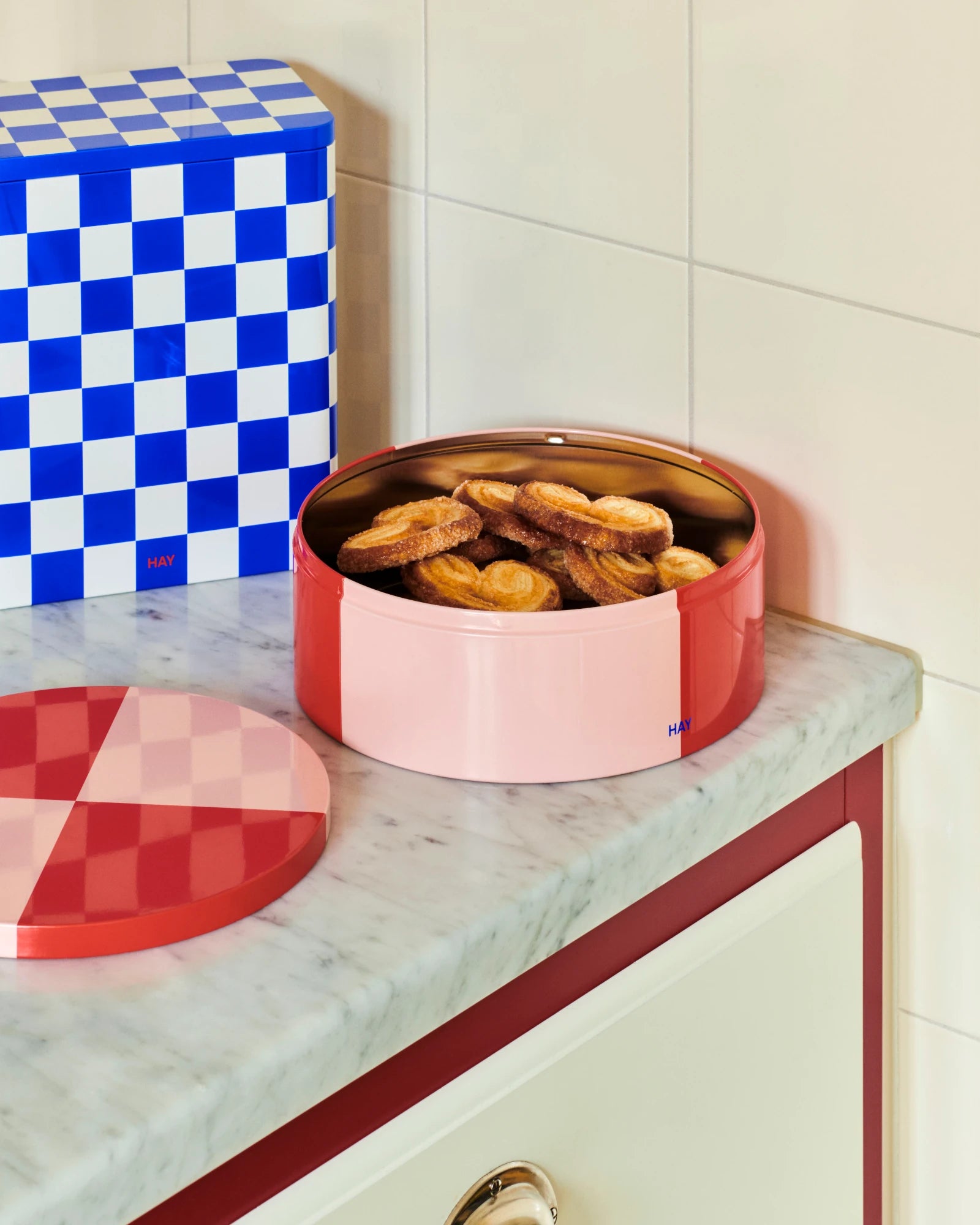 Round Tin Container in Red and Light pInk by HAY full of biscuits on a counter top  | Lifestory
