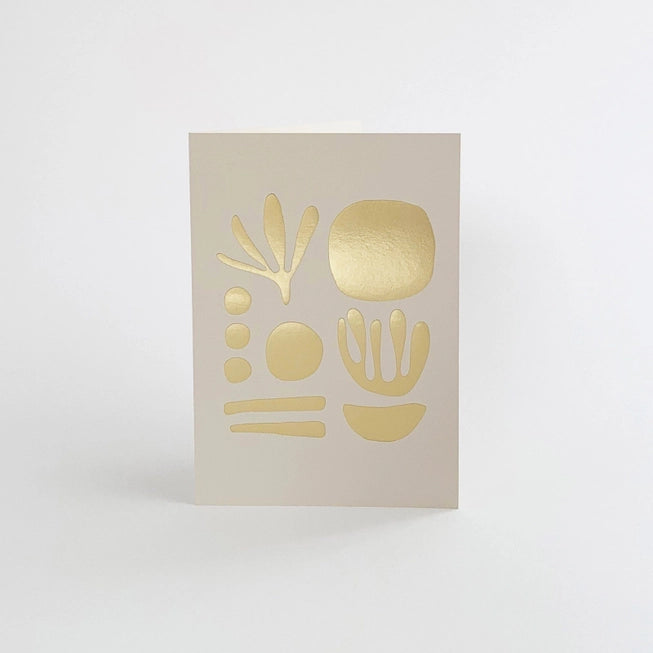 Tom Pigeon seaweed card featuring a brass foiled geometric design on a mist white background