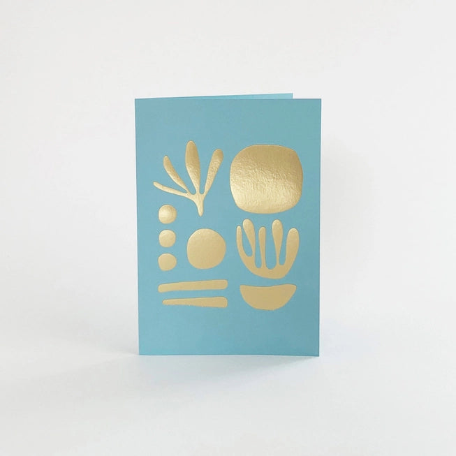 Tom Pigeon seaweed card featuring a brass foiled geometric design on a sky blue background